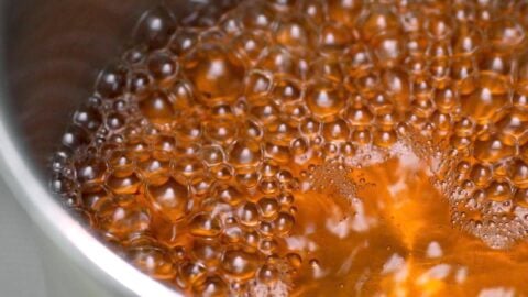 Dashi stock boiling in a stainless steel pot.