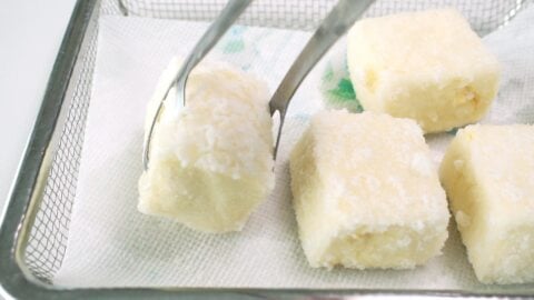 Fried tofu draining on paper towel lined rack.