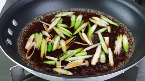 Scallion stems simmering in savory sweet dashi broth.