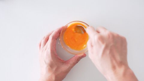 Mixing egg yolk wash for the top crust of apple pie.