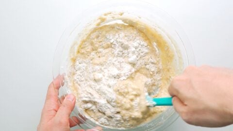 Folding banana bread batter together with a spatula.