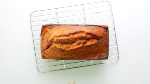 Loaf of banana bread cooling on a wire rack.