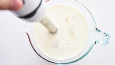 Cream and eggwhite mixture being mixed with a hand blender for making gelatin-less panna cotta.