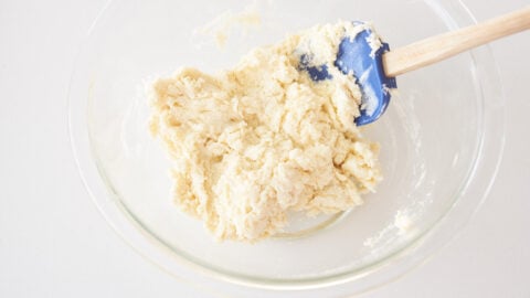 Mix yogurt into the flour mixture to make the biscuit dough for the blueberry cobbler.