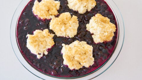 Top the blueberry filling with sugared biscuits to assemble the cobbler.