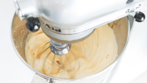 Whipping eggs and sugar in a silver Kitchen Aid standmixer for blueberry olive oil cake.