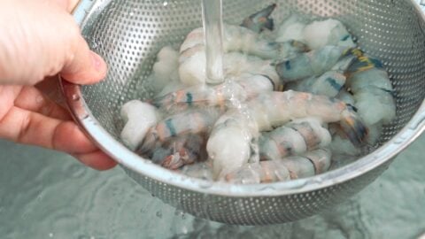 Rinsing shrimp in a colander.