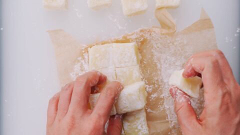 Dusting butter mochi with potato starch.