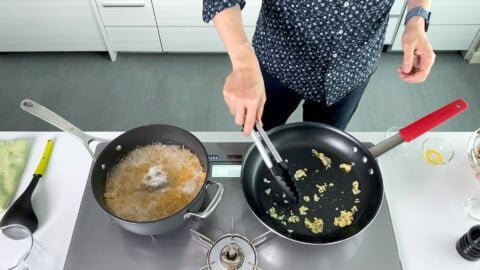 Sautéing garlic in a frying pan for pasta.