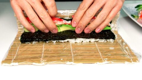 Roll one edge of the rice and nori over the fillings.