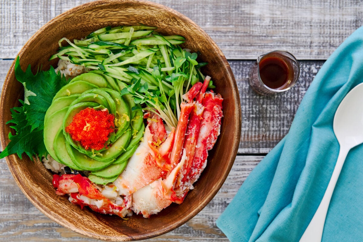 This California roll in a bowl has savory crab, creamy avocado, crunchy tobiko, and crispy cucumbers on a bed of nori and sushi rice.