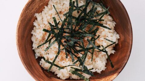 Sushi rice, nori and sesame seeds in a wooden bowl.