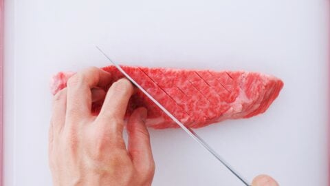 Tenderize the steak by cutting slits in it.