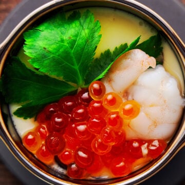 Chawanmushi (Japanese Steamed Egg) topped with ikura, shrimp, and mitsuba leaves.