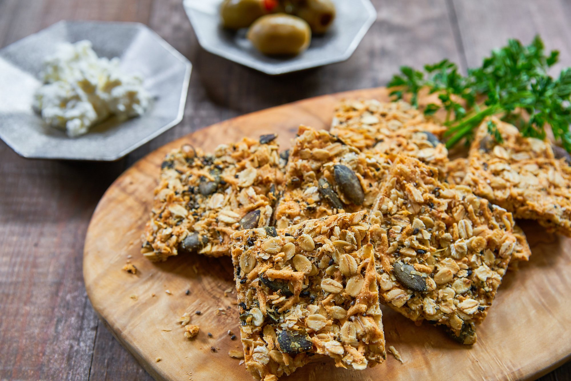 Cheesy and delicious savory granola bars are loaded with cheddar, parmesan, oats, pumpkin seeds, sesame seeds, and chia seeds and baked until crisp.