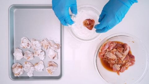 Dusting marinated chicken in potato starch for karaage.