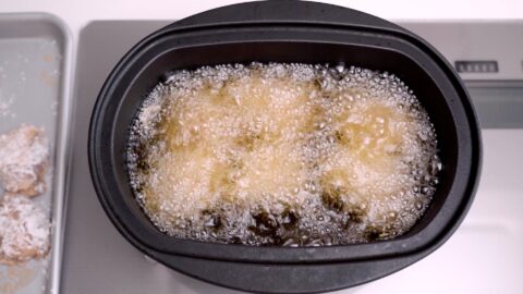 Karaage frying in oil in a cast iron pot.