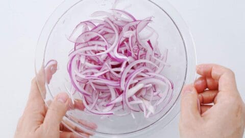 Tossing sliced red onions in a lime juice, salt, and sugar to quick pickle.