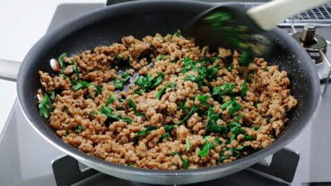 Basil chicken lettuce wrap filling in a frying pan.