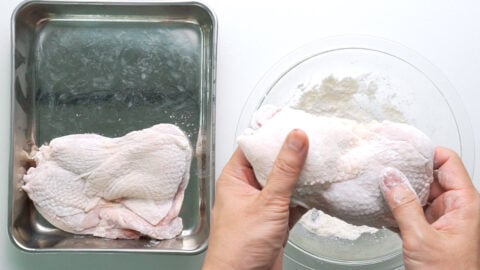 Dusting chicken in flour.