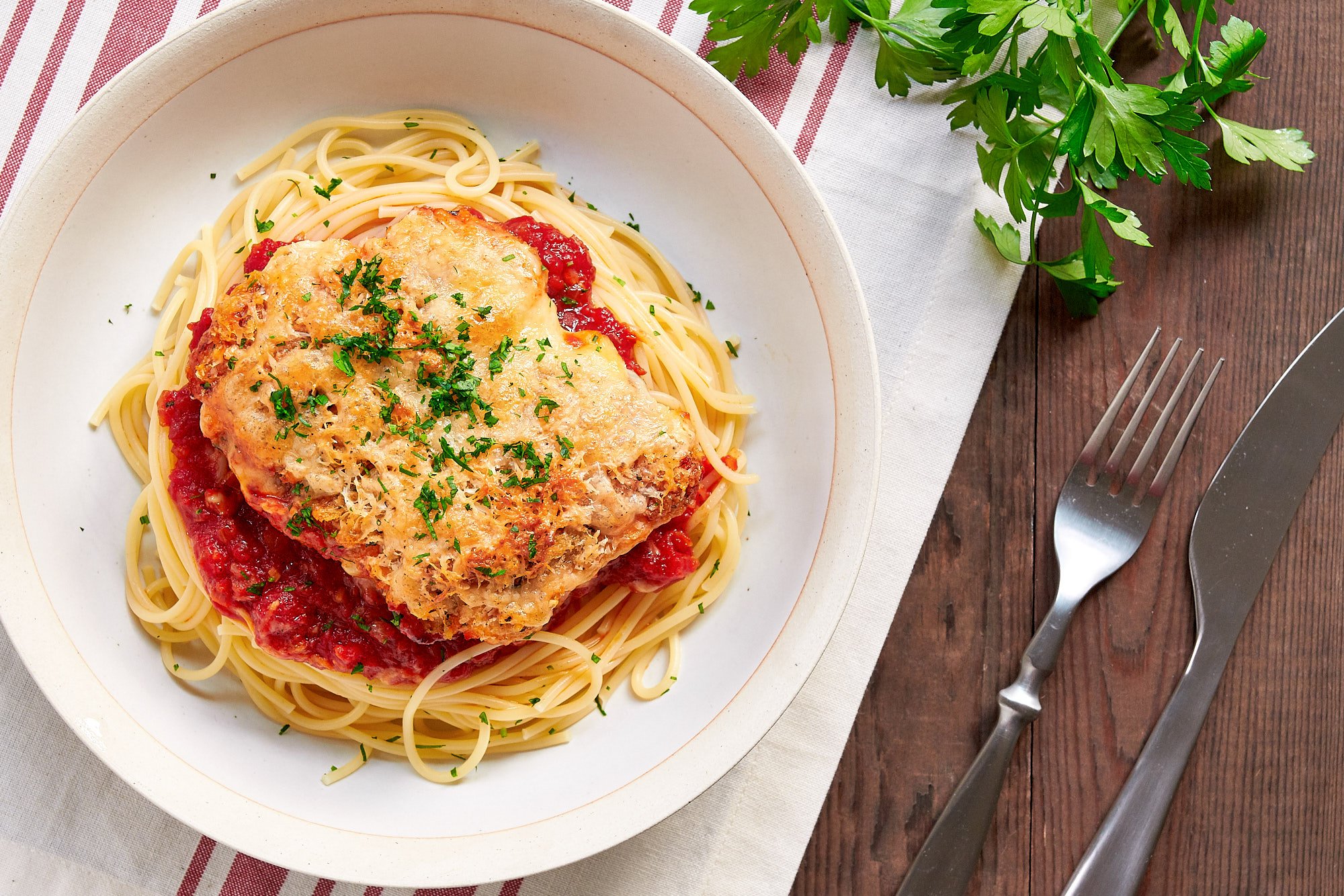 Cheese and seasoned breadcrumbs form a crisp top to this easy baked chicken parmesan.