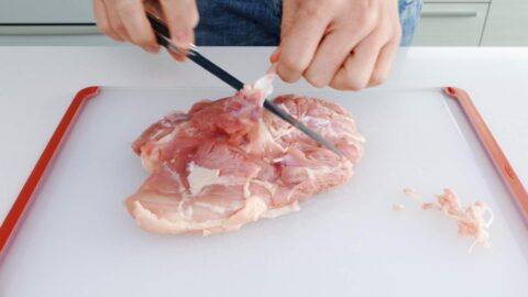 Trimming chicken leg.