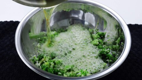 Pouring hot oil over ginger and scallions.