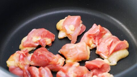 Chicken thighs frying in pan for udon noodles.