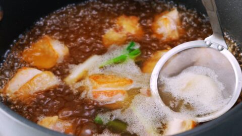 Skimming chicken broth for Japanese udon noodle soup.