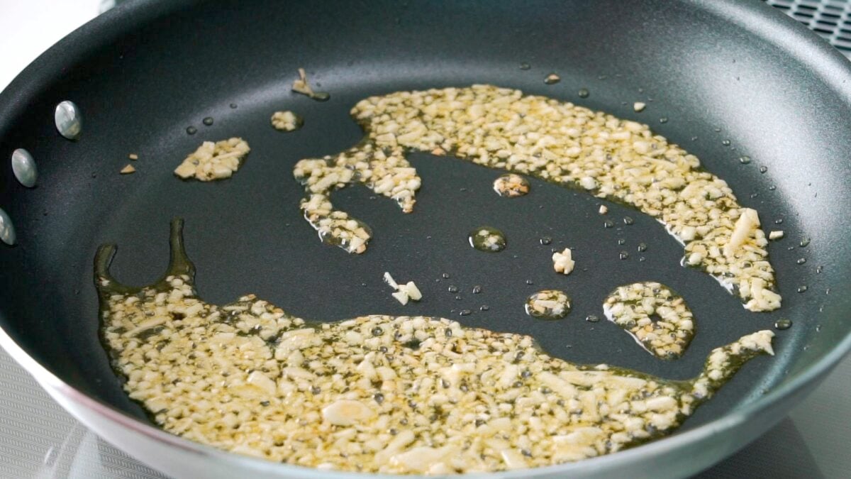 Garlic frying in olive oil for making chickpea pasta.