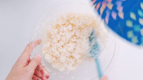 Mixing a bowl of sushi rice.