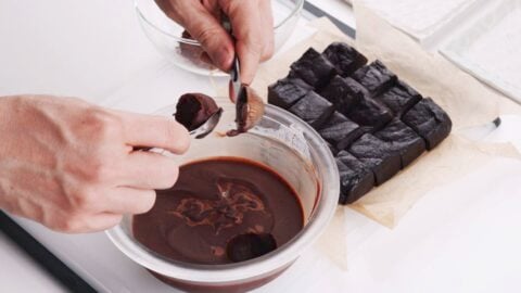 Scooping chocolate ganache into spheres for making mochi.