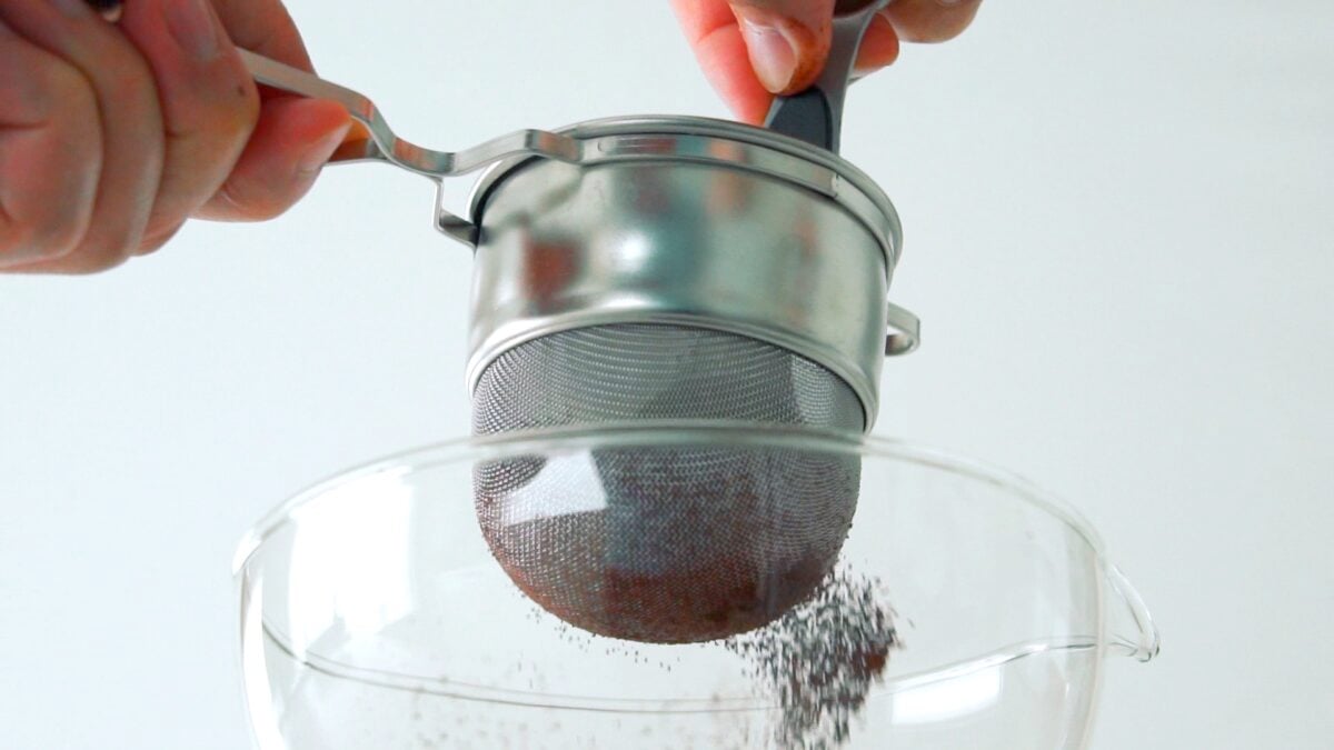 Sifting cocoa powder to make the batter for mug cake.