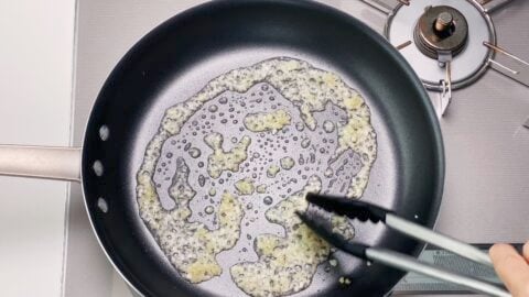 Frying garlic and ginger in a frying pan for making a Chinese stir-fry.