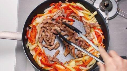 Stir-frying pork and vegetables for Chop Suey.