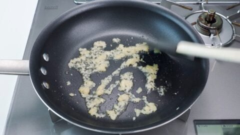 Frying garlic and ginger in a frying pan.