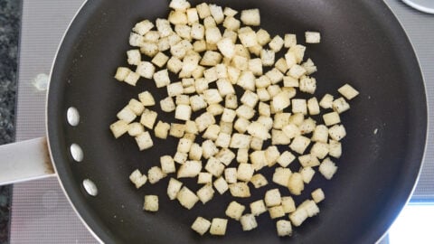 Frying croutons in butter as a topping for corn potage.