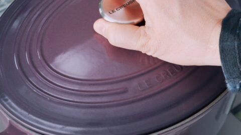 Covering purple dutch oven with a lid.