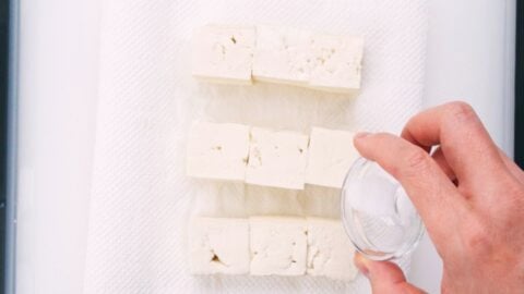 Salting tofu to extract excess water.