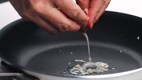 Squeezing ginger juice from pulp into frying pan.