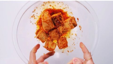 Tossing crispy tofu with ginger garlic glaze.