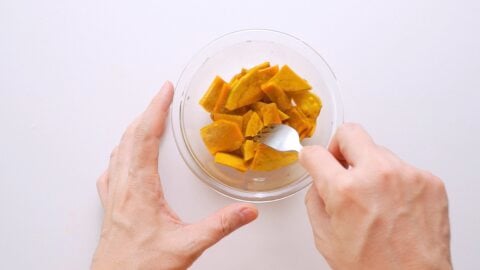 Testing steamed kabocha squash with a fork.