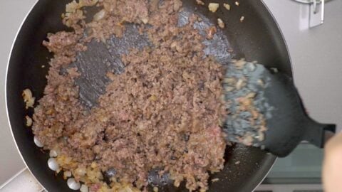 Ground beef cooking in a frying pan.