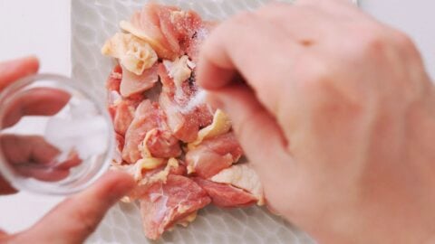 Salting chicken pieces.