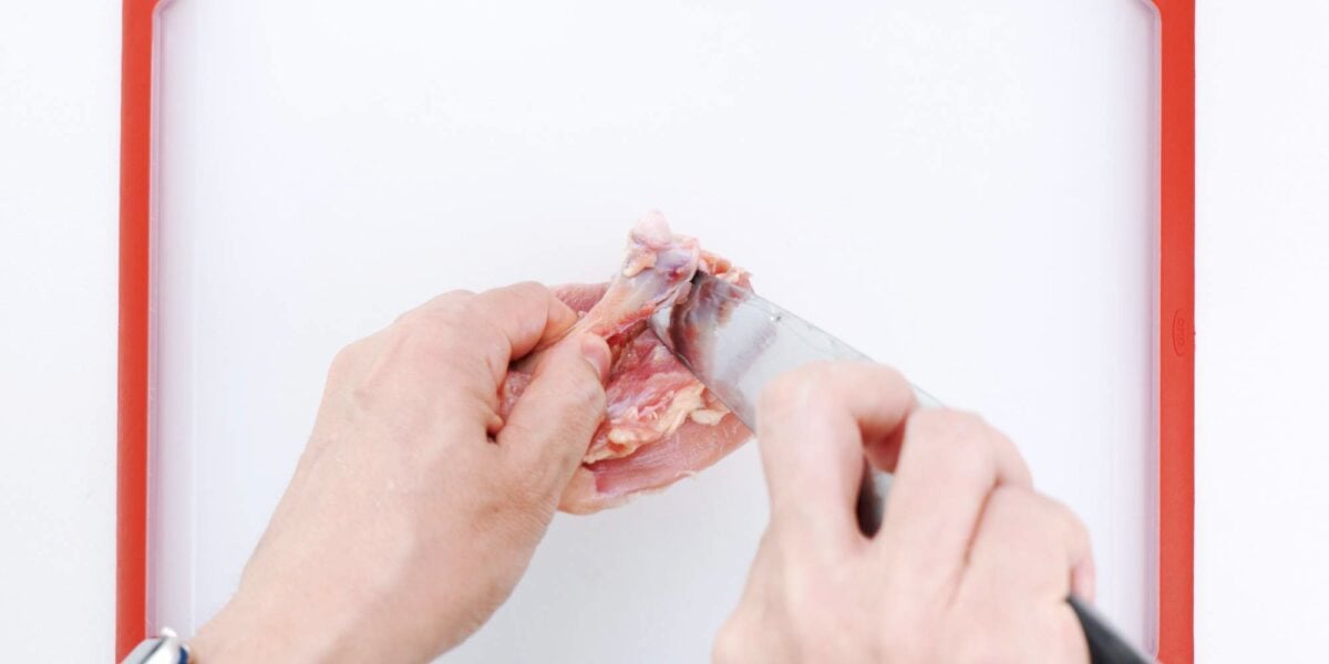 Separating chicken thigh bone from thigh meat.