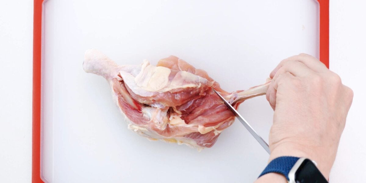 Remove thigh bone from chicken leg.