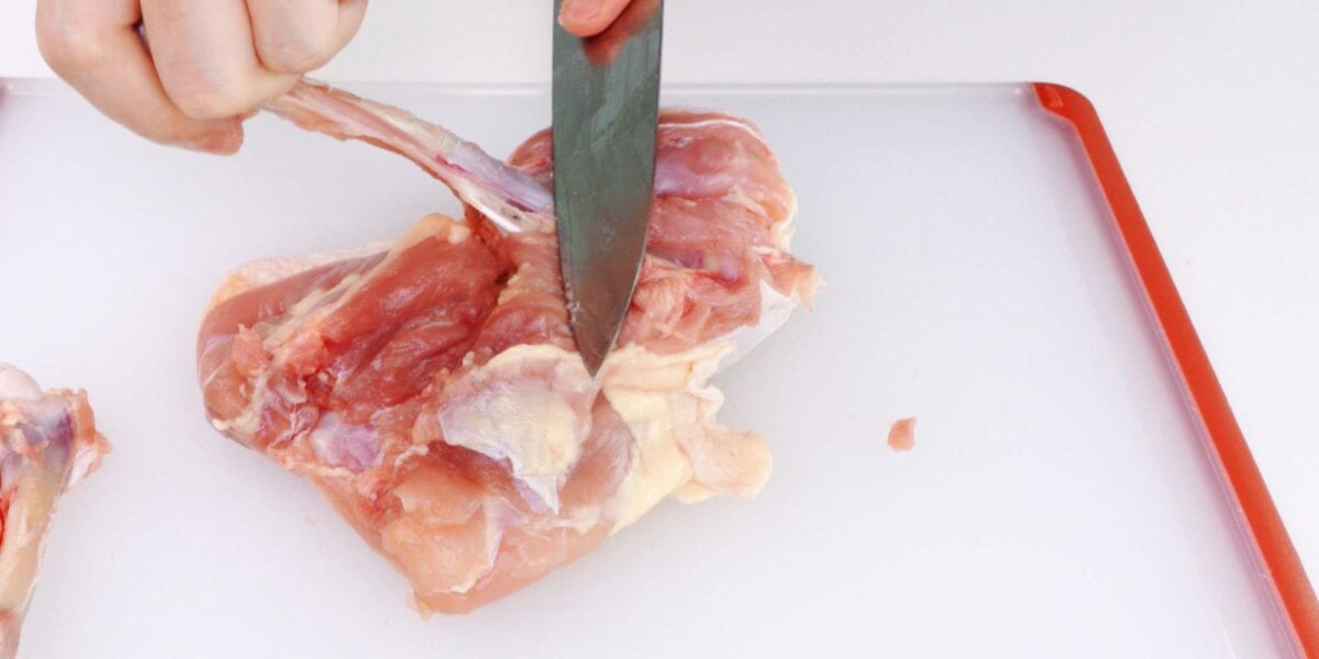 Remove drumstick bone from chicken leg.