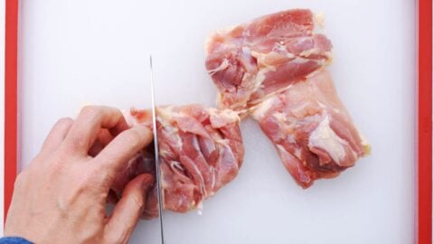 Cutting chicken thigh.