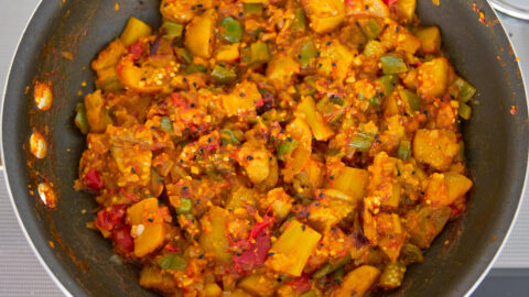 Finished eggplant curry is vibrant both in color and taste with tender eggplant pungent spices and tangy tomatoes.