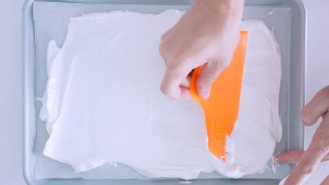 Spreading meringue into a thin layer on a baking sheet.